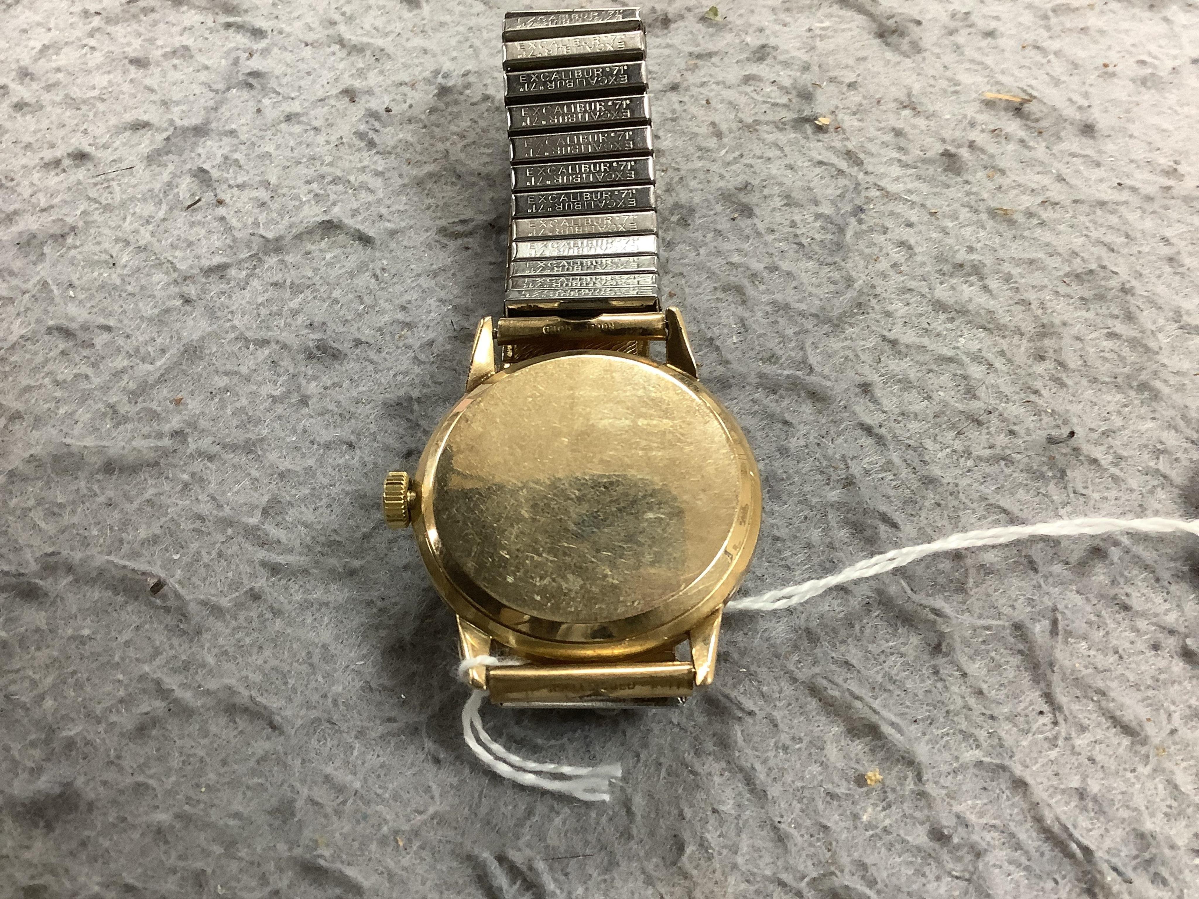 A gentleman's yellow metal Omega manual wind wrist watch, with baton numerals, case diameter 34mm, on an associated rolled gold flexible strap. Condition - fair